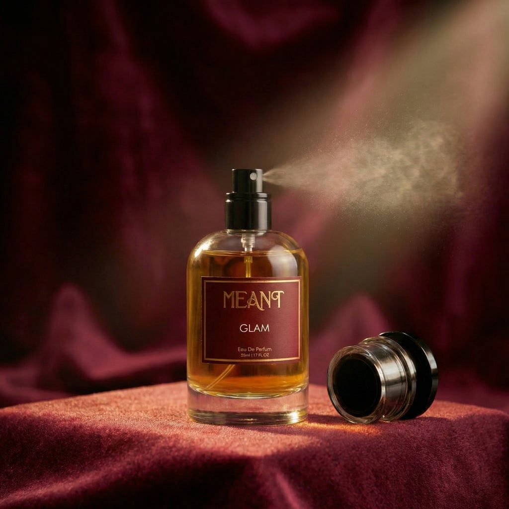 Perfume bottle labeled 'MEANT Glam' on a red fabric background showing its super fine mist spray nozzle.