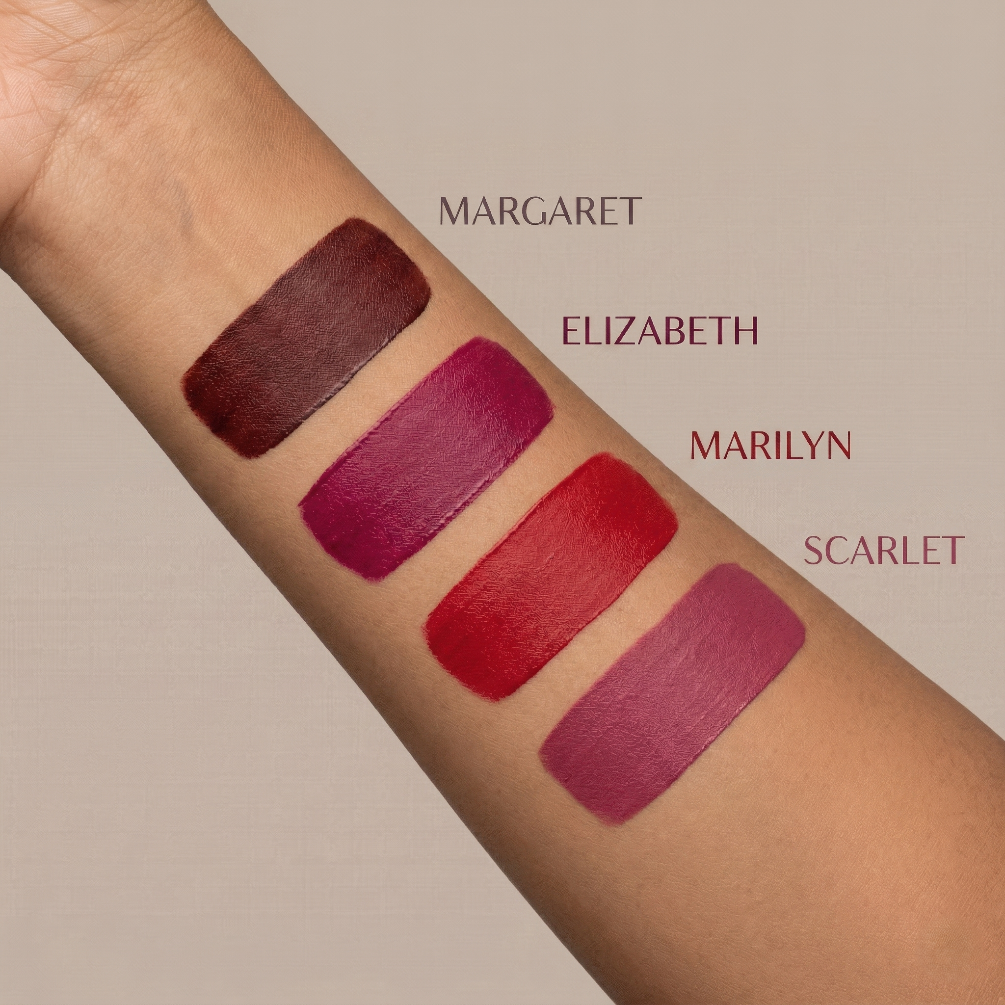 Long lasting matte liquid lipstick combo swatches of all four shades on arm labeled 'Margaret', 'Elizabeth', 'Marilyn', and 'Scarlet' against a neutral background.